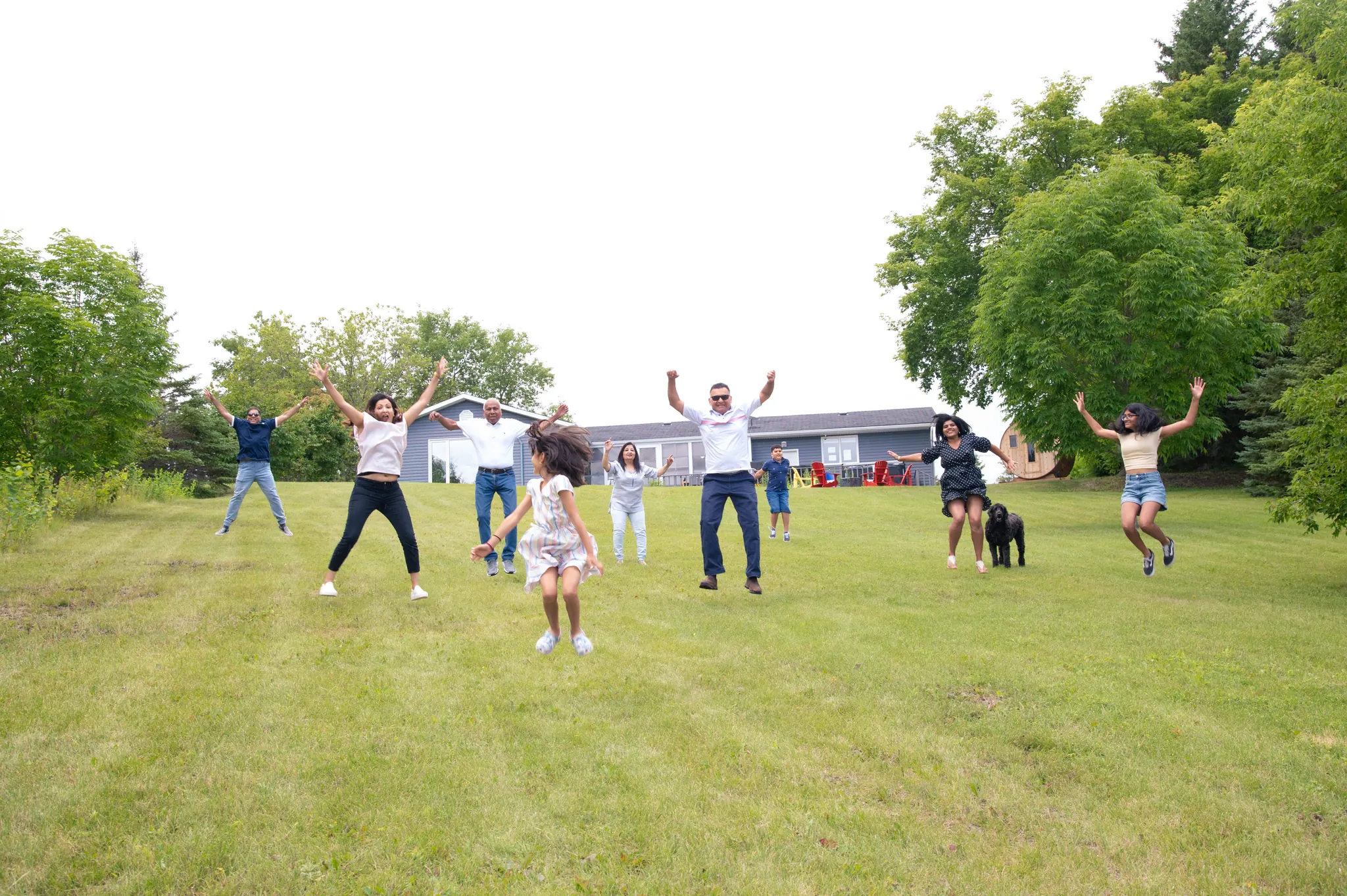 A family jumping for joy on the lawn at the cabins